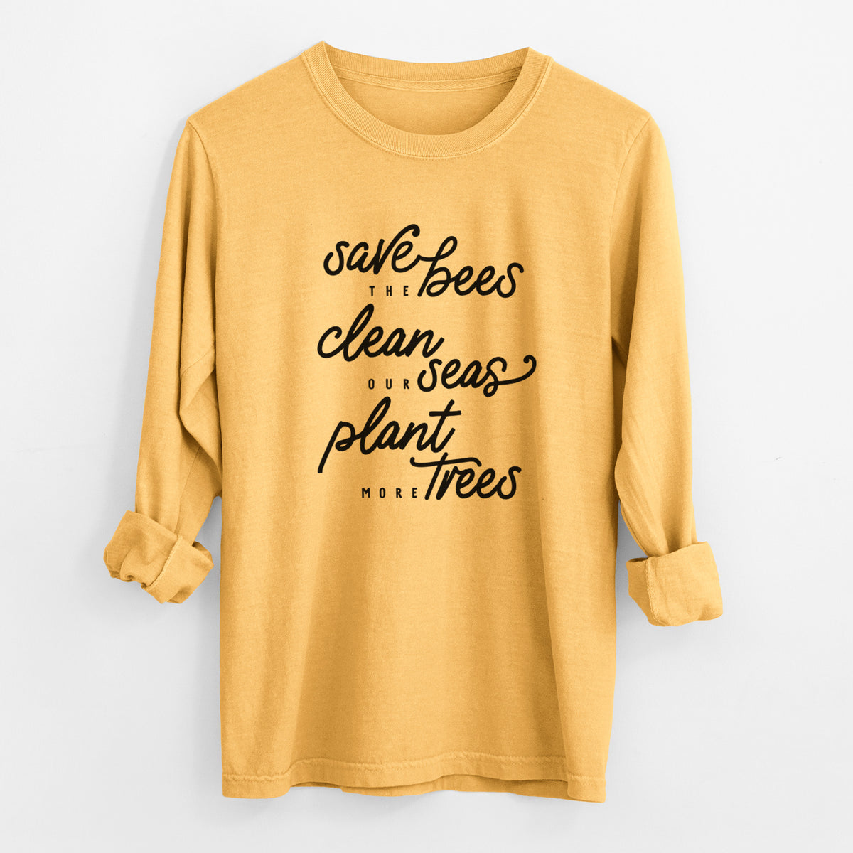 Golden wheat yellow Comfort Colors long sleeve shirt laid flat with the cuffs rolled, printed with black hand-lettered words reading Save the Bees, Clean Our Seas, Plant More Trees.