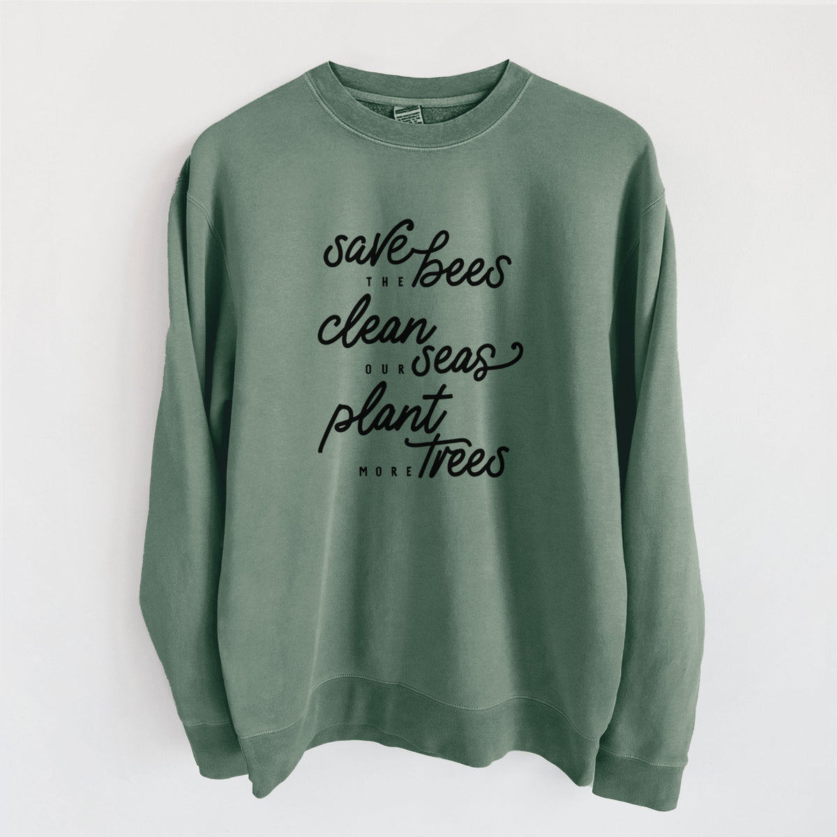 Alpine green pigment dyed crewneck sweatshirt laid flat, printed with black hand-lettered words reading Save the Bees, Clean Our Seas, Plant More Trees.