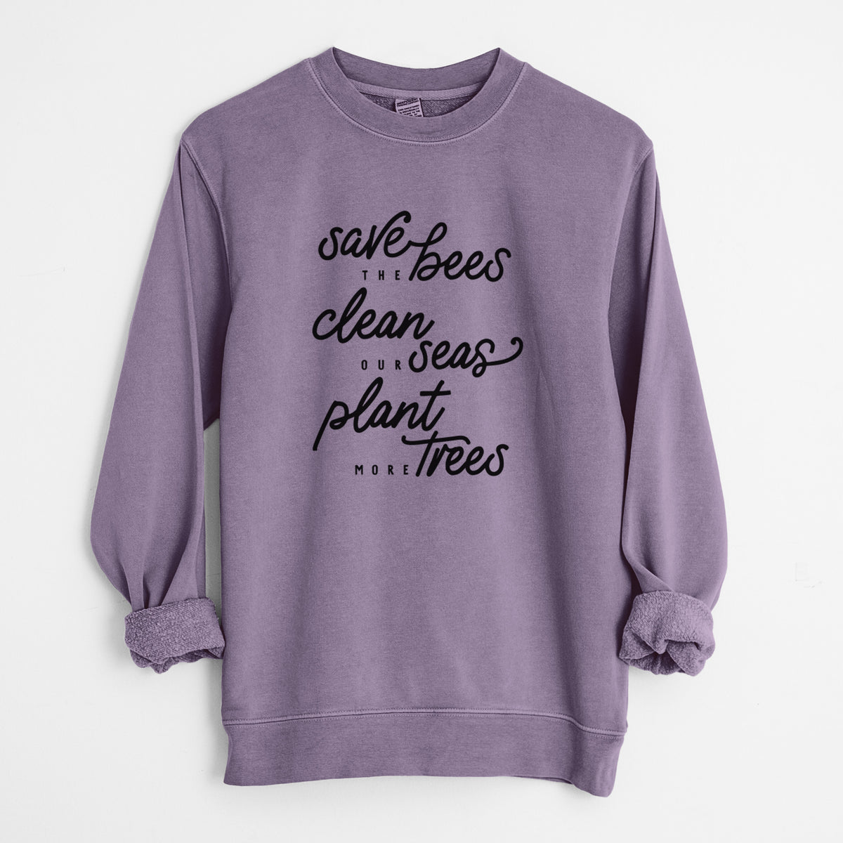 Plum purple pigment dyed crewneck sweatshirt laid flat with the sleeves rolled, printed with black hand-lettered words reading Save the Bees, Clean Our Seas, Plant More Trees.