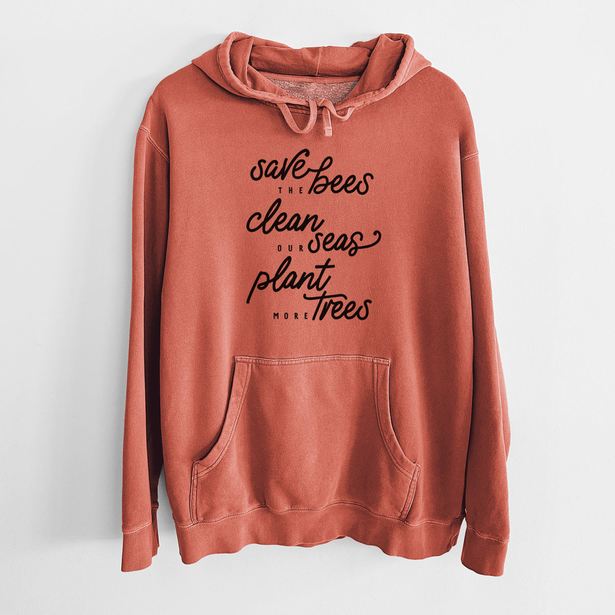 Amber orange pigment dyed hoodie laid flat, printed with black hand-lettered words reading Save the Bees, Clean Our Seas, Plant More Trees.