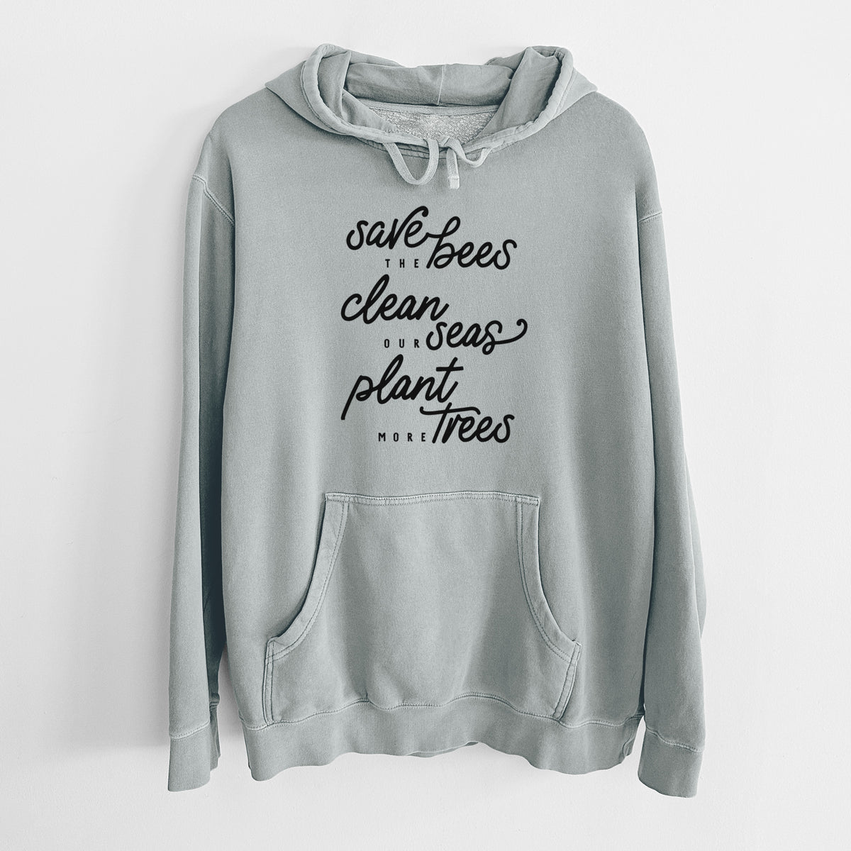 Sage green pigment dyed hoodie laid flat, printed with black hand-lettered words reading Save the Bees, Clean Our Seas, Plant More Trees.