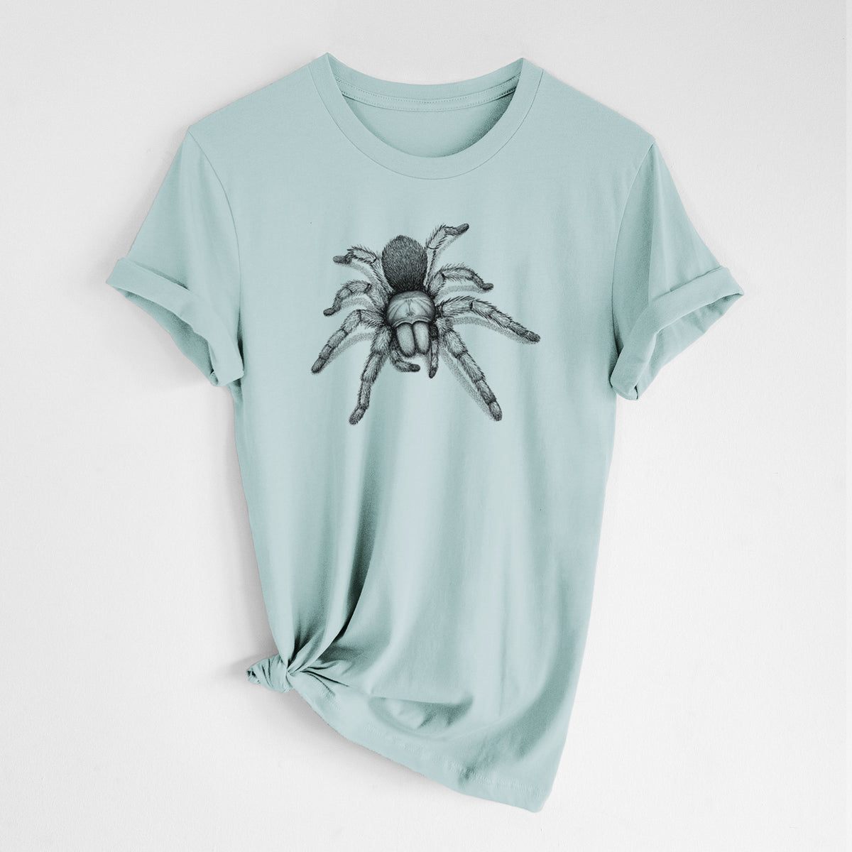 Dusty blue lightweight cotton t-shirt laid flat with the sleeves rolled, printed with a detailed black ink illustration of a desert blonde tarantula.