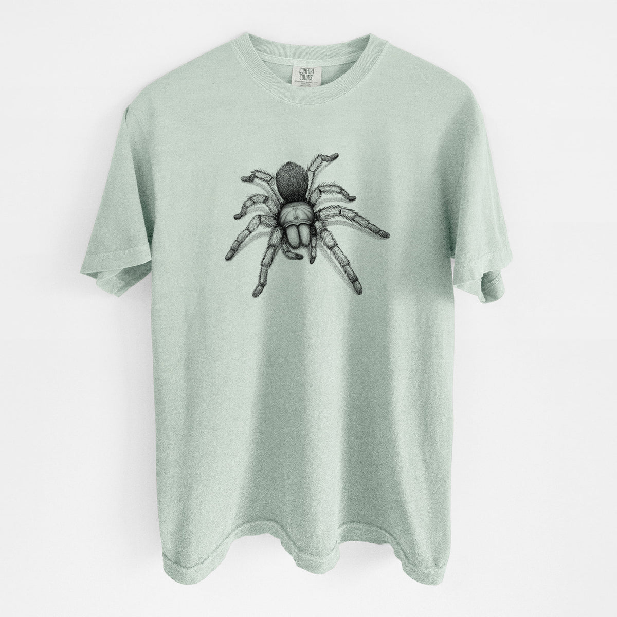 Bay green Comfort Colors t-shirt laid flat, printed with a detailed black ink illustration of a desert blonde tarantula.