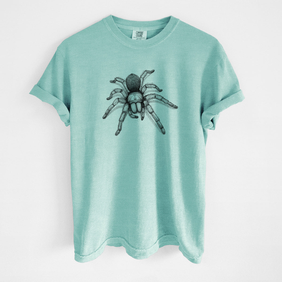 Chalky mint Comfort Colors t-shirt laid flat, printed with a detailed black ink illustration of a desert blonde tarantula.