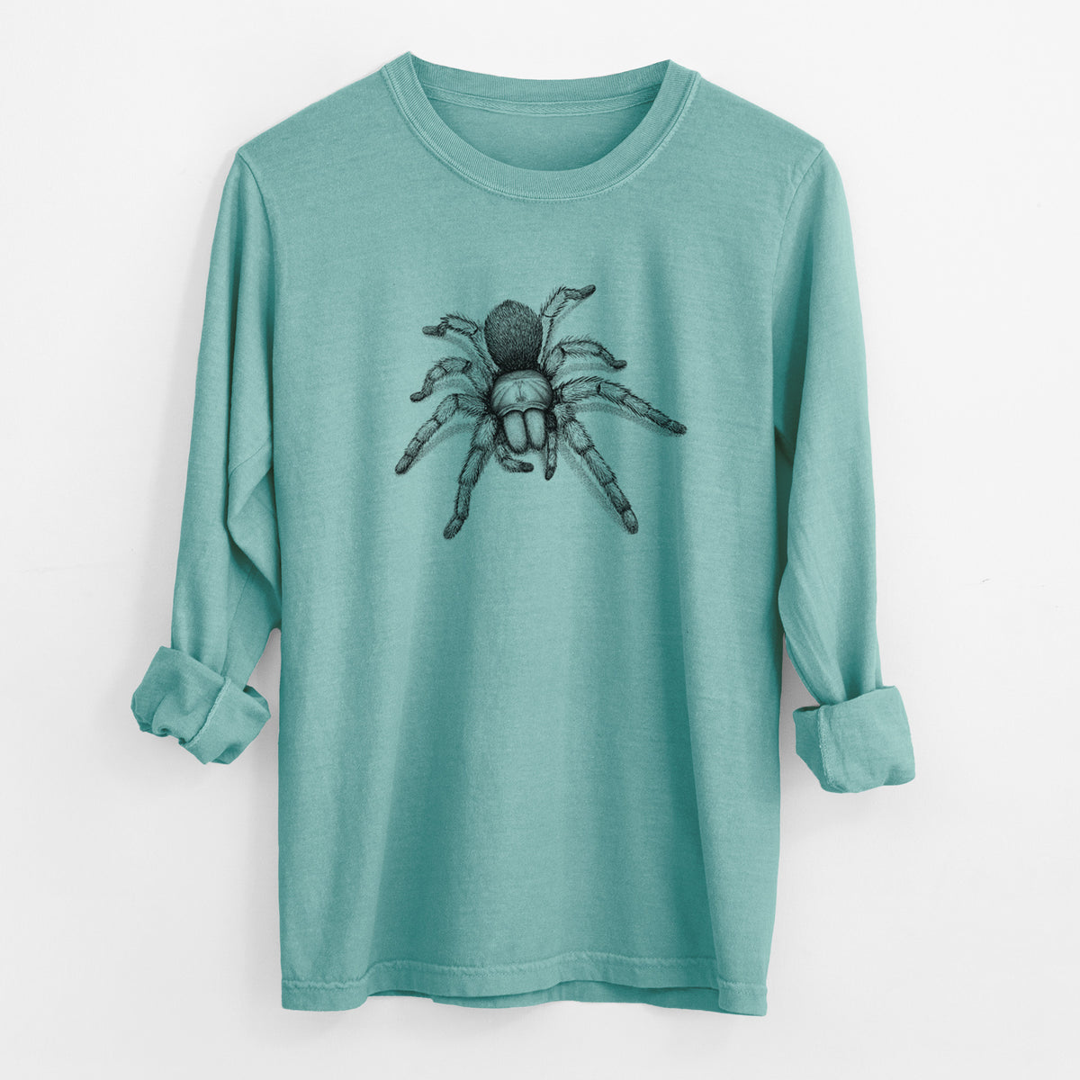 Reef green Comfort Colors long sleeve shirt laid flat with the cuffs rolled, printed with a detailed black ink illustration of a desert blonde tarantula.