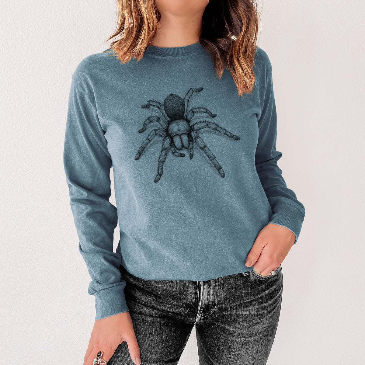 Steel blue Comfort Colors long sleeve shirt printed with a detailed black ink illustration of a desert blonde tarantula, shown in a lifestyle photo.