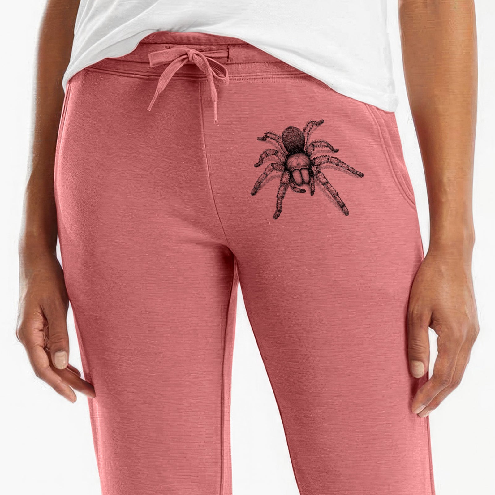 Front of dusty rose Cali Wave sweatpants, printed with a detailed black ink illustration of a desert blonde tarantula on the leg.