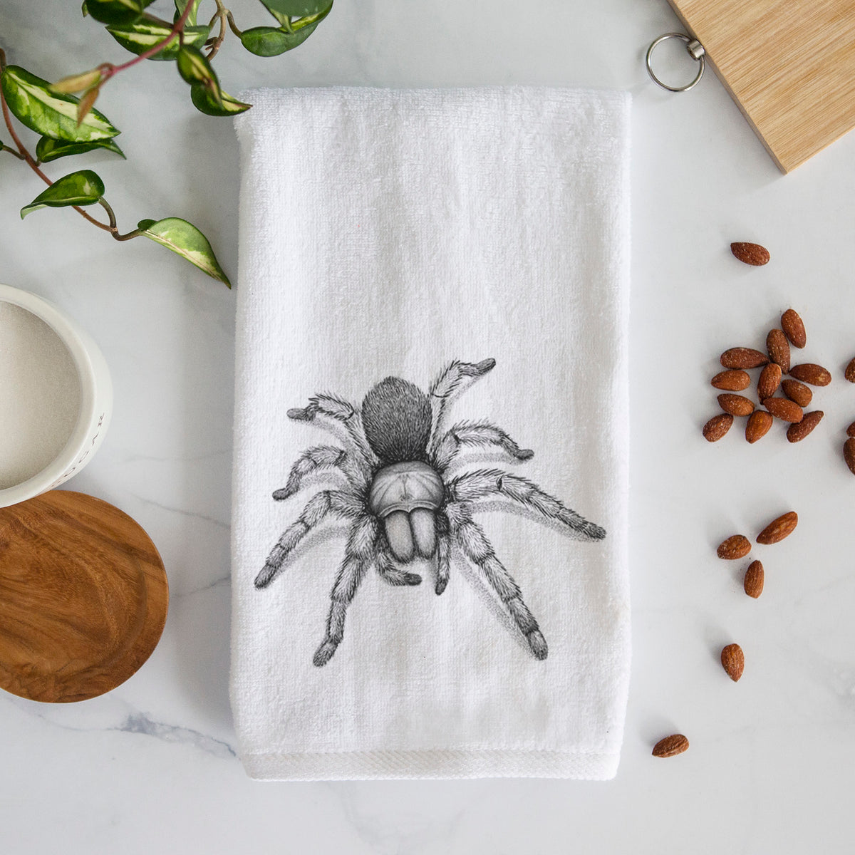 White hand towel printed with a detailed black ink illustration of a desert blonde tarantula.