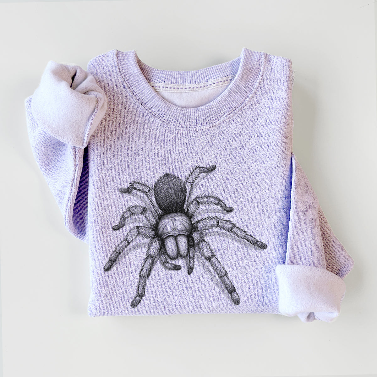 Ice purple knit sweatshirt printed with a detailed black ink illustration of a desert blonde tarantula, styled flat.