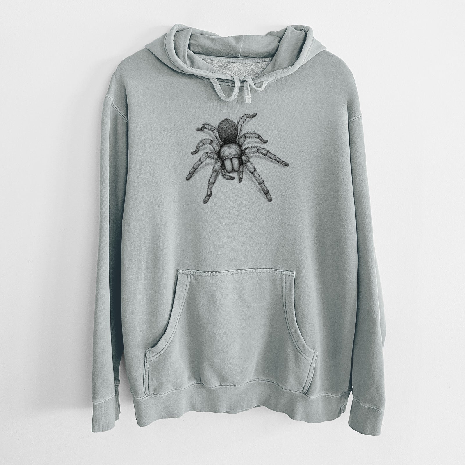 Sage green pigment dyed hoodie laid flat, printed with a detailed black ink illustration of a desert blonde tarantula.