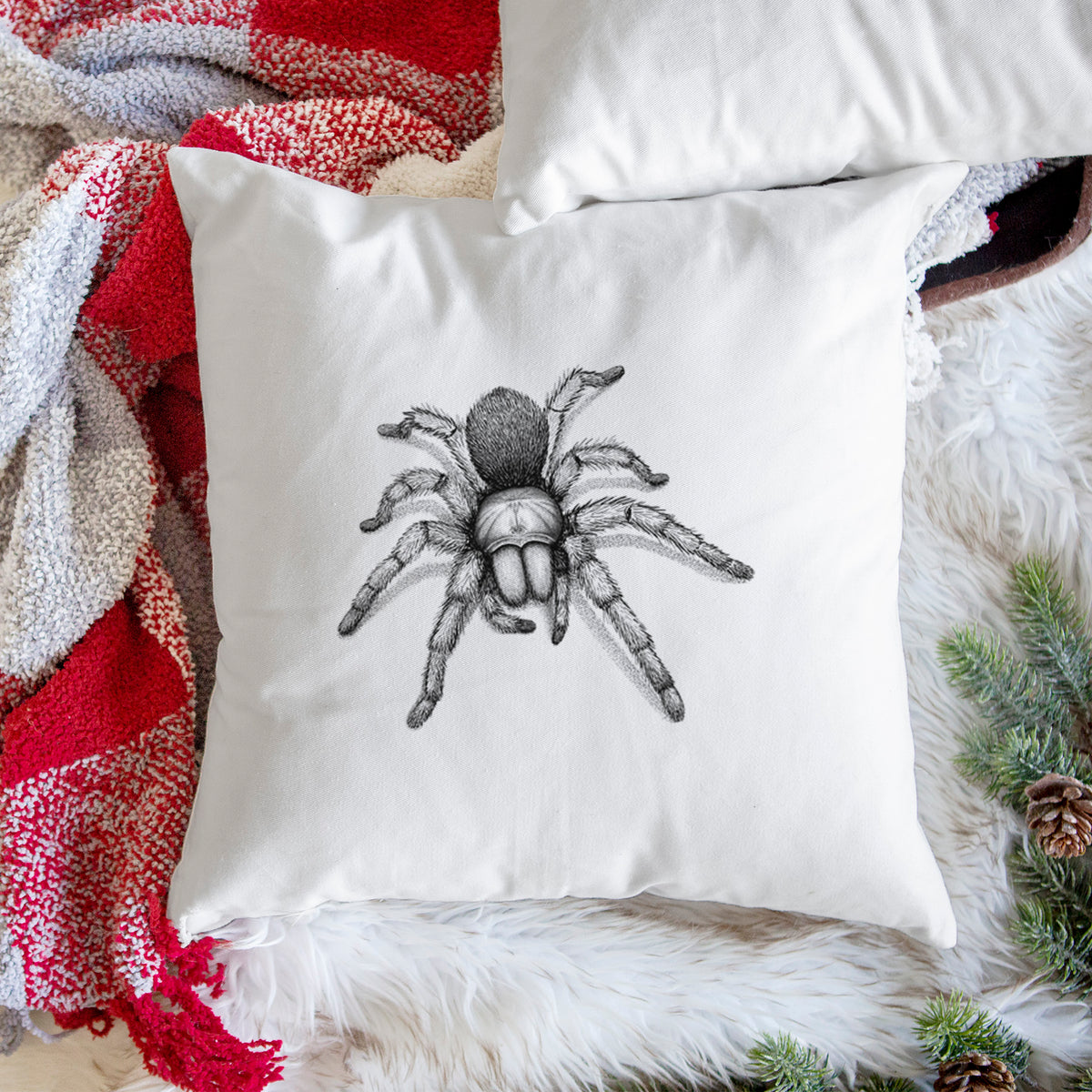 White pillow cover printed with a detailed black ink illustration of a desert blonde tarantula, on a woven chair.