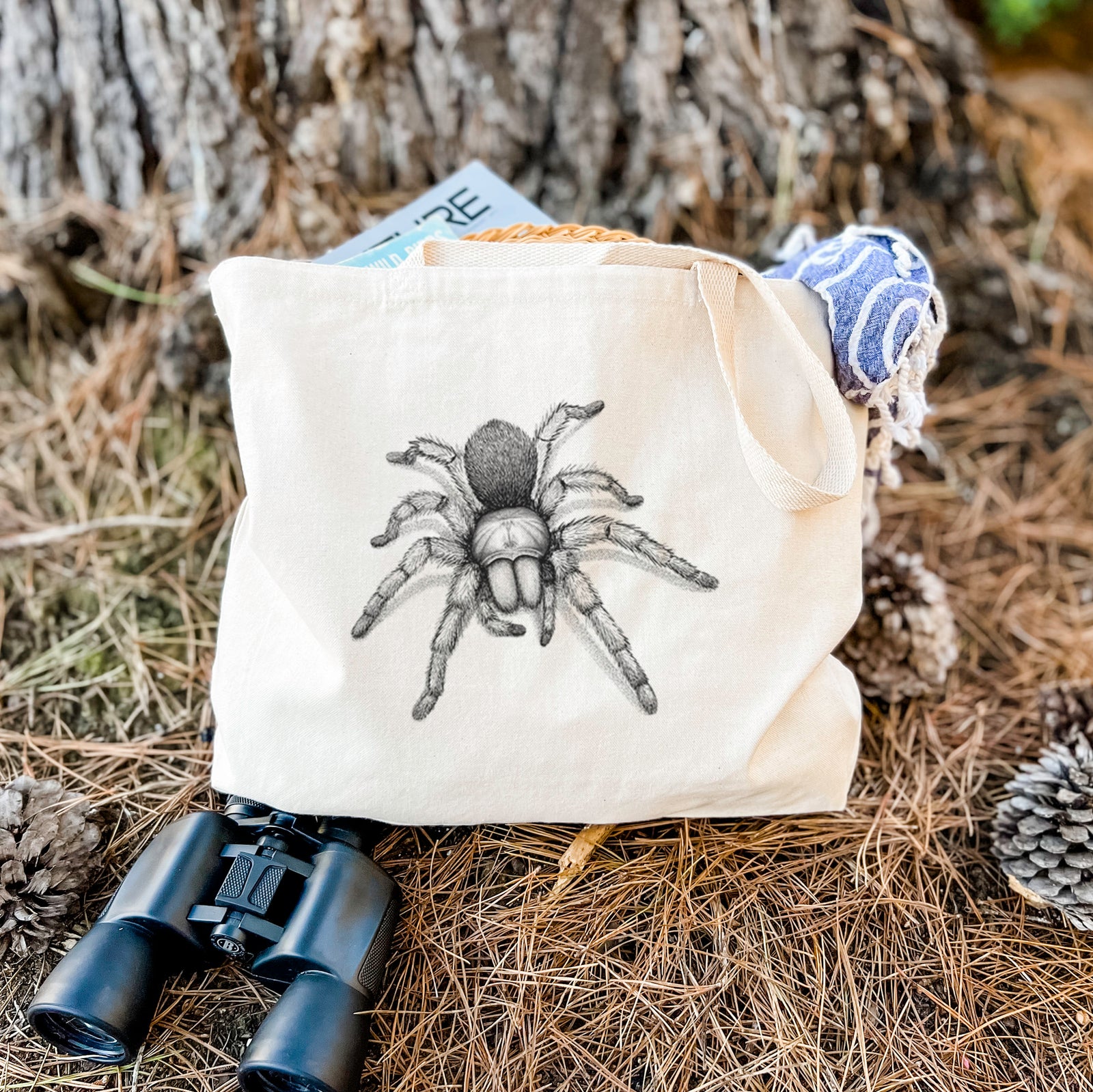 Natural canvas tote bag printed with a detailed black ink illustration of a desert blonde tarantula.