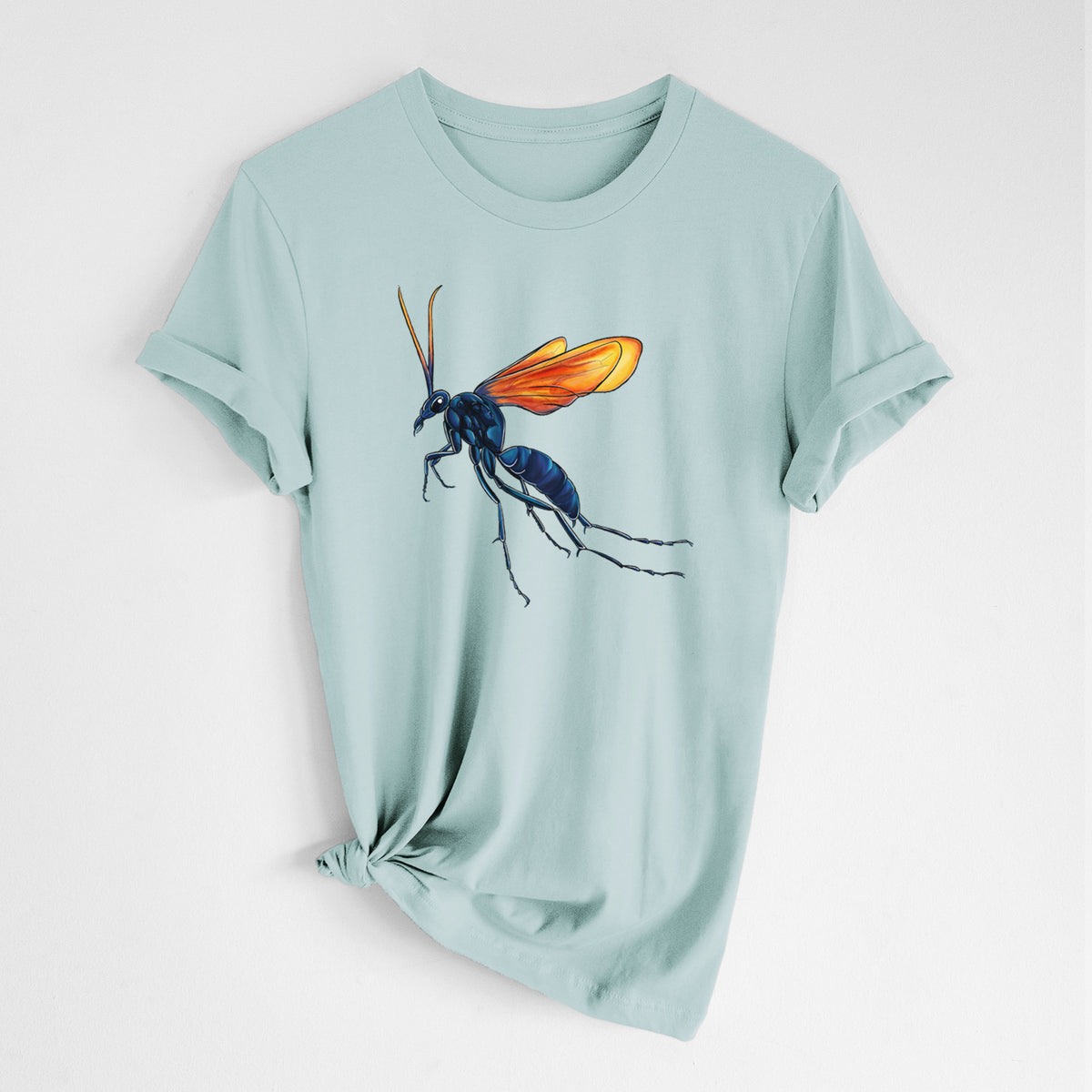 Dusty blue lightweight cotton t-shirt laid flat with the sleeves rolled, printed with a full-color illustration of a tarantula hawk wasp with a blue body and orange wings.