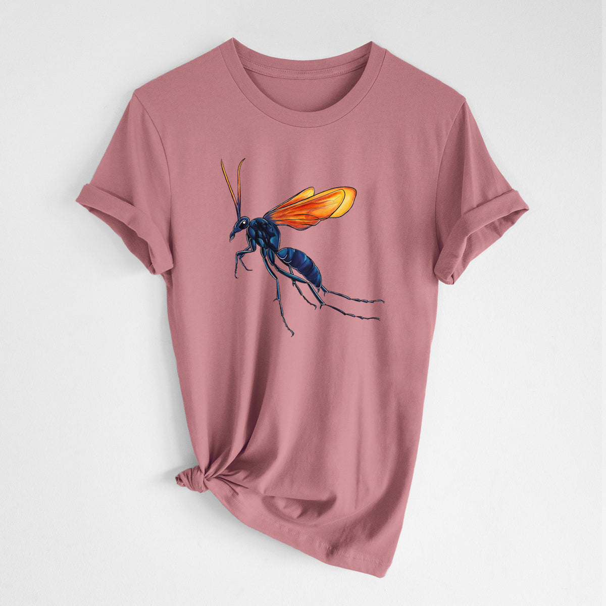 Mauve pink lightweight cotton t-shirt laid flat with the sleeves rolled, printed with a full-color illustration of a tarantula hawk wasp with a blue body and orange wings.
