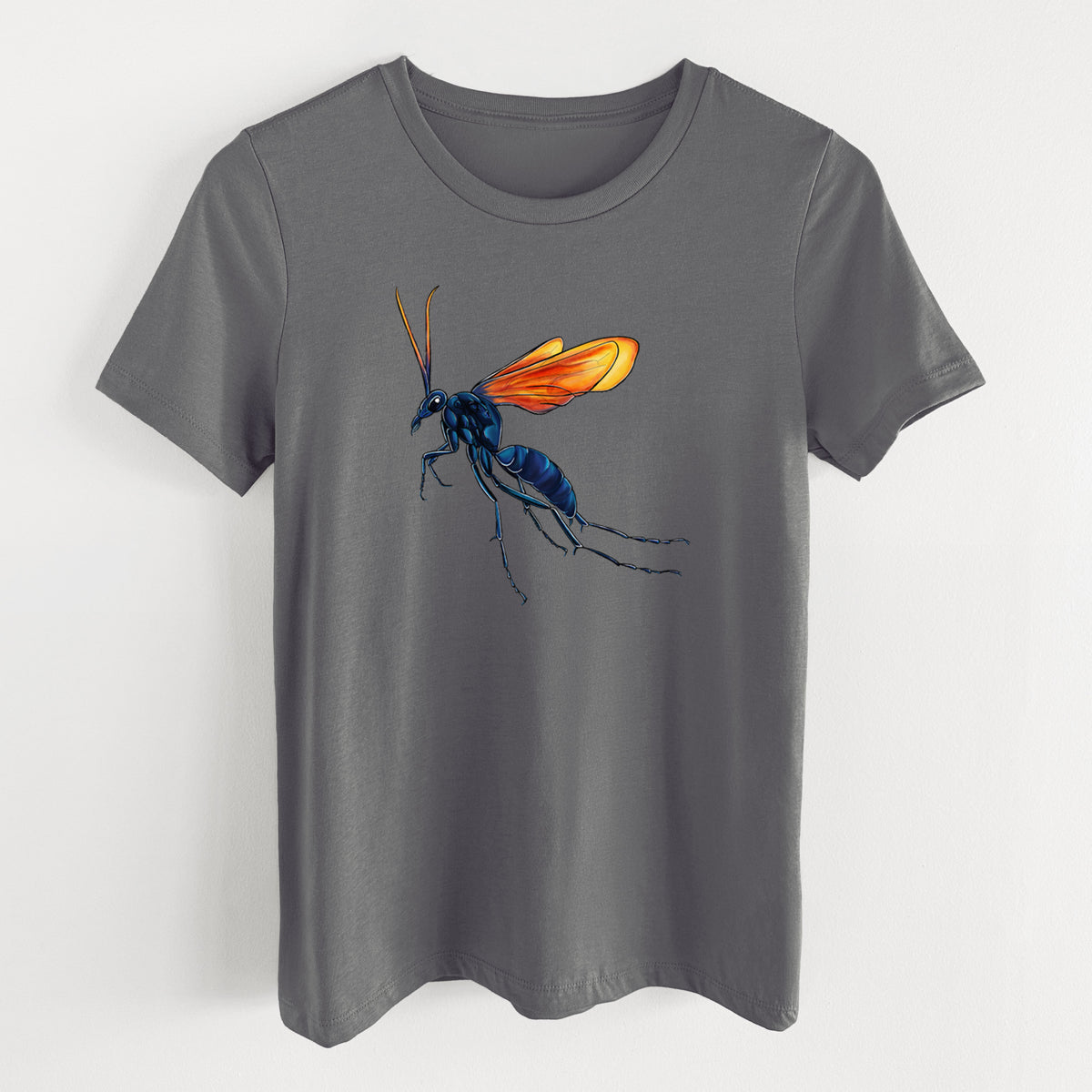 Asphalt women's relaxed fit cotton t-shirt laid flat, printed with a full-color illustration of a tarantula hawk wasp with a blue body and orange wings.