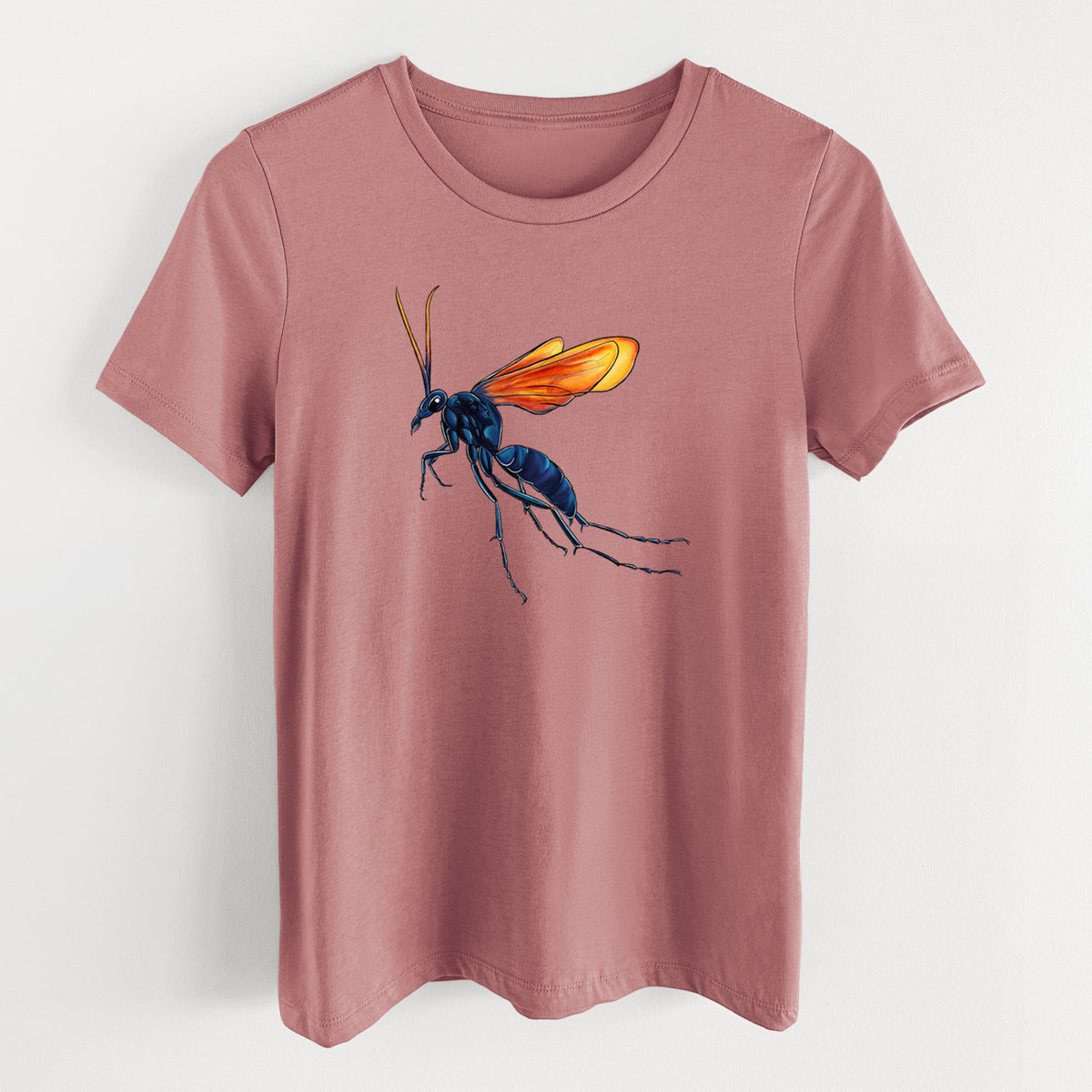 Mauve pink women's relaxed fit cotton t-shirt laid flat, printed with a full-color illustration of a tarantula hawk wasp with a blue body and orange wings.