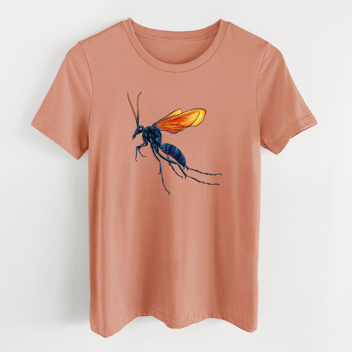 Terracotta orange women's relaxed fit cotton t-shirt laid flat, printed with a full-color illustration of a tarantula hawk wasp with a blue body and orange wings.
