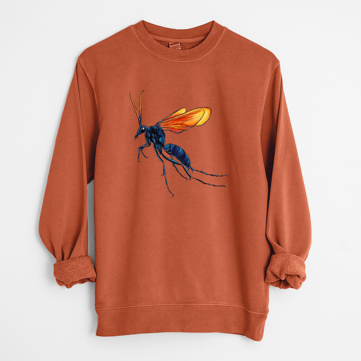 Amber orange pigment dyed crewneck sweatshirt laid flat with the sleeves rolled, printed with a full-color illustration of a tarantula hawk wasp with a blue body and orange wings.