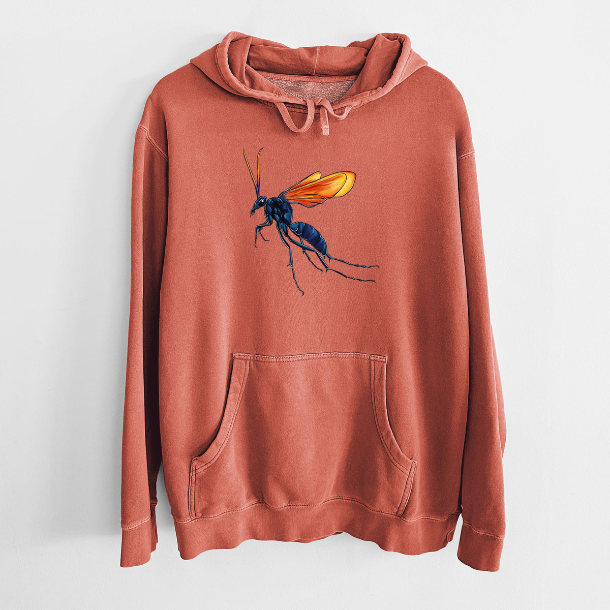 Amber orange pigment dyed hoodie laid flat, printed with a full-color illustration of a tarantula hawk wasp with a blue body and orange wings.