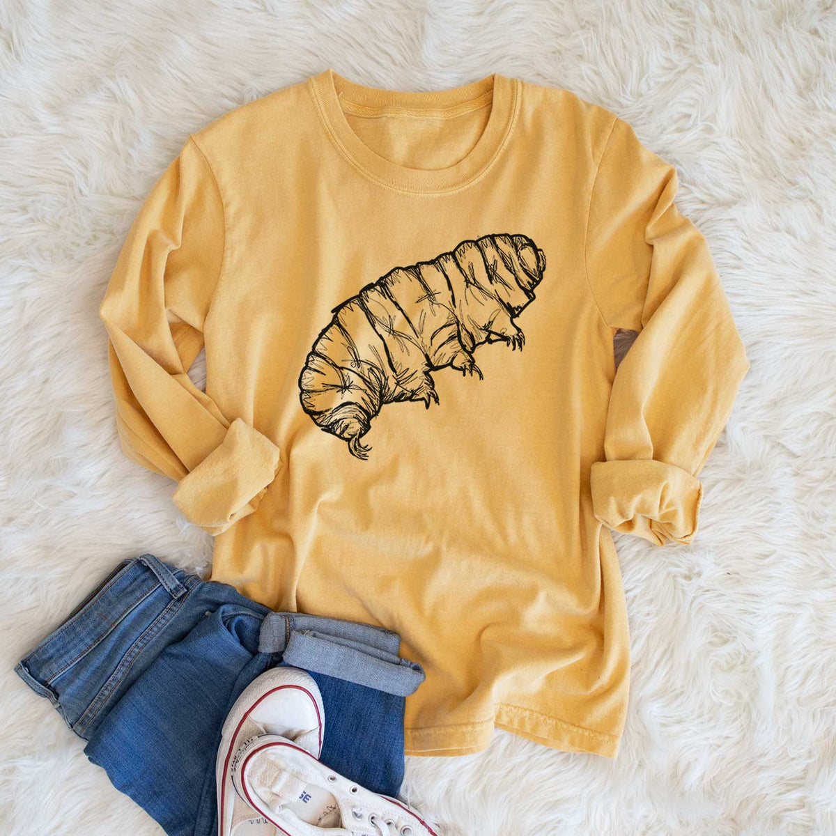 Golden wheat yellow Comfort Colors long sleeve shirt printed with a detailed black ink illustration of a tardigrade, or water bear, shown in a lifestyle photo.