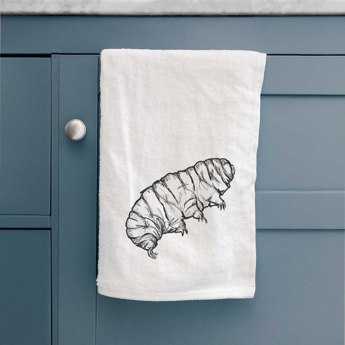 White hand towel printed with a detailed black ink illustration of a tardigrade, or water bear.