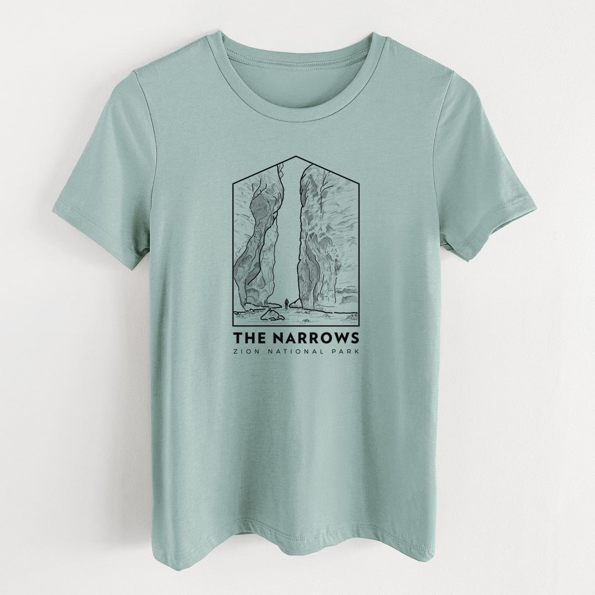 Dusty blue women's relaxed fit cotton t-shirt laid flat, printed with a black line art badge of the tall canyon walls of The Narrows, with the words The Narrows.
