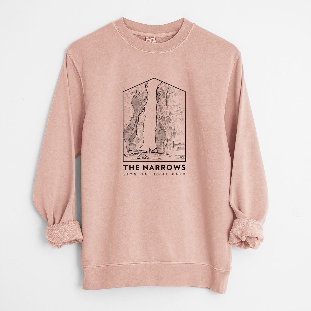 Dusty pink pigment dyed crewneck sweatshirt laid flat with the sleeves rolled, printed with a black line art badge of the tall canyon walls of The Narrows, with the words The Narrows.