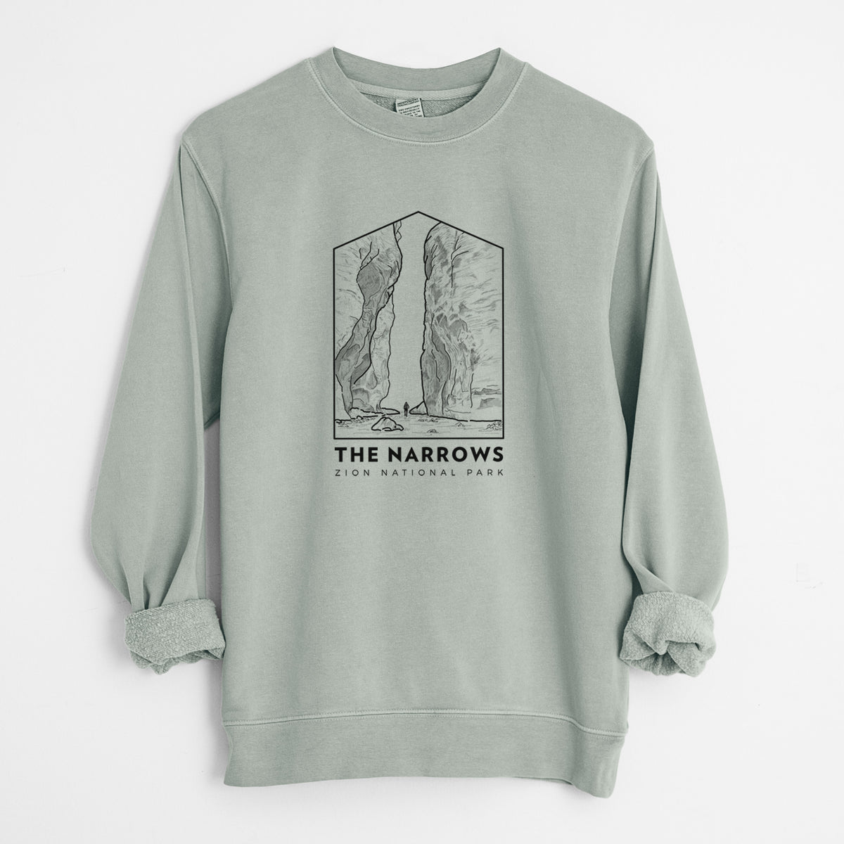 Sage green pigment dyed crewneck sweatshirt laid flat with the sleeves rolled, printed with a black line art badge of the tall canyon walls of The Narrows, with the words The Narrows.