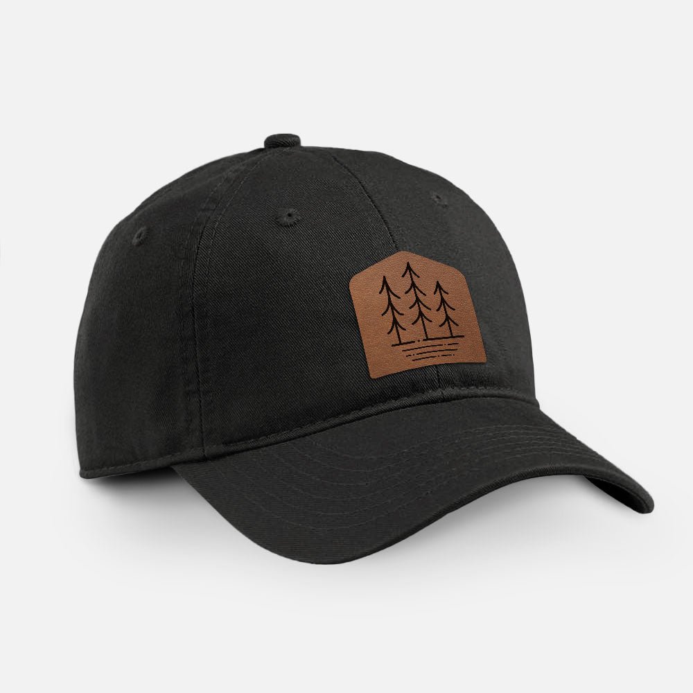 Black cotton baseball hat with a brown leather patch engraved with three pine trees on the front.
