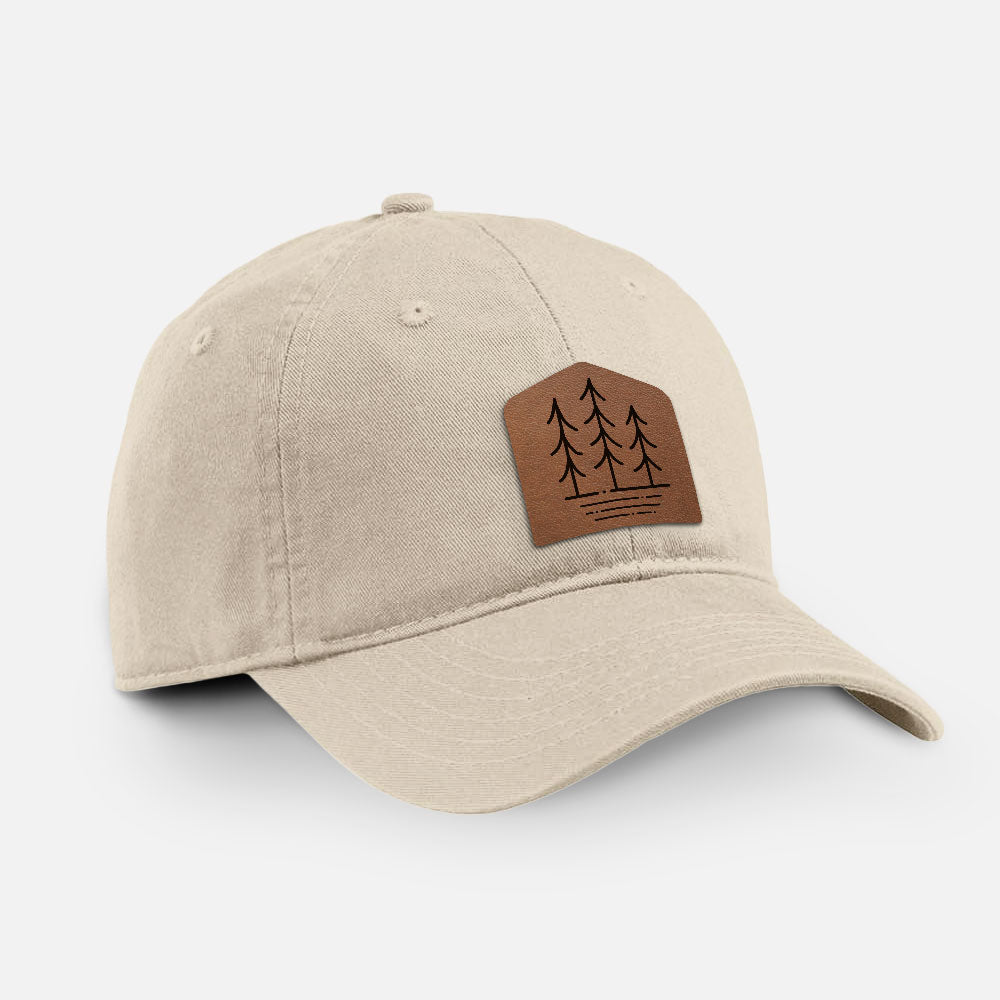 Stone cotton baseball hat with a brown leather patch engraved with three pine trees on the front.