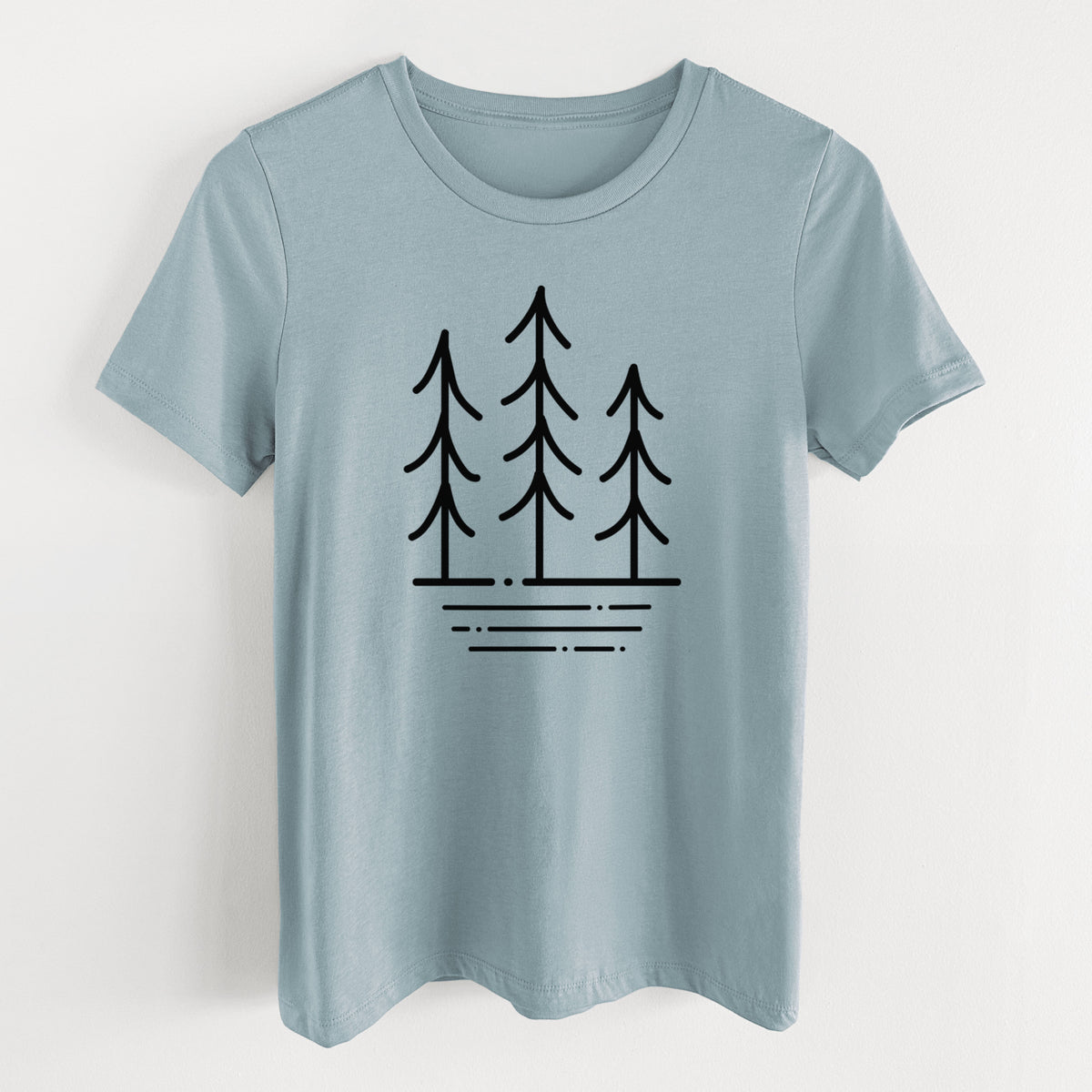 Vintage denim women's relaxed fit cotton t-shirt laid flat, printed with black line art of three simple pine trees above horizontal lines.