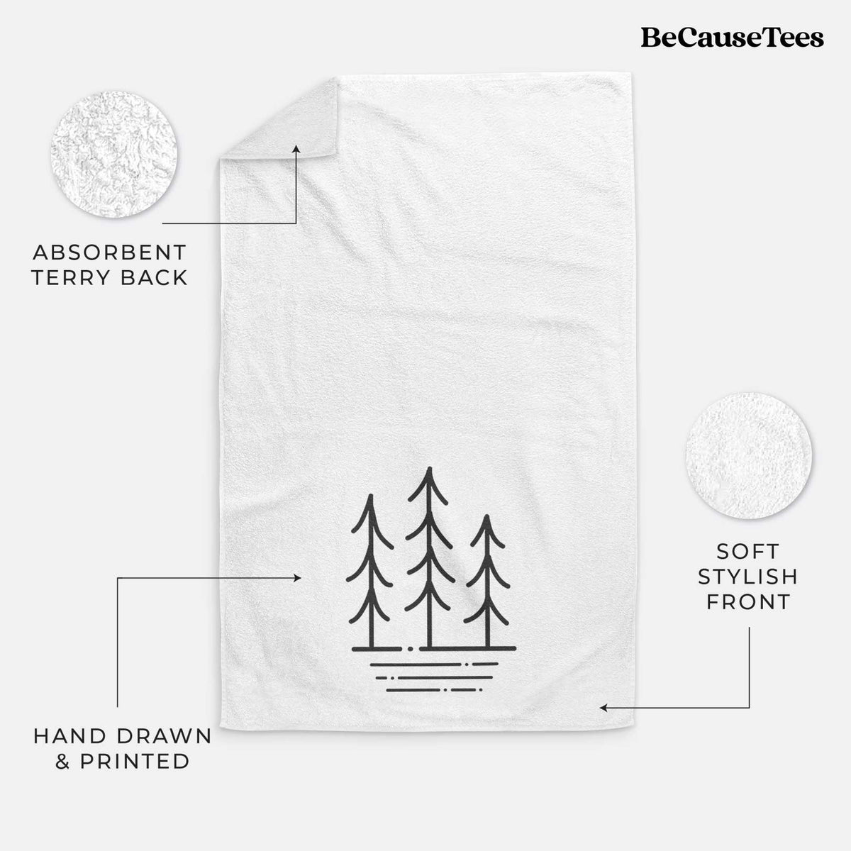 White hand towel printed with black line art of three simple pine trees above horizontal lines.