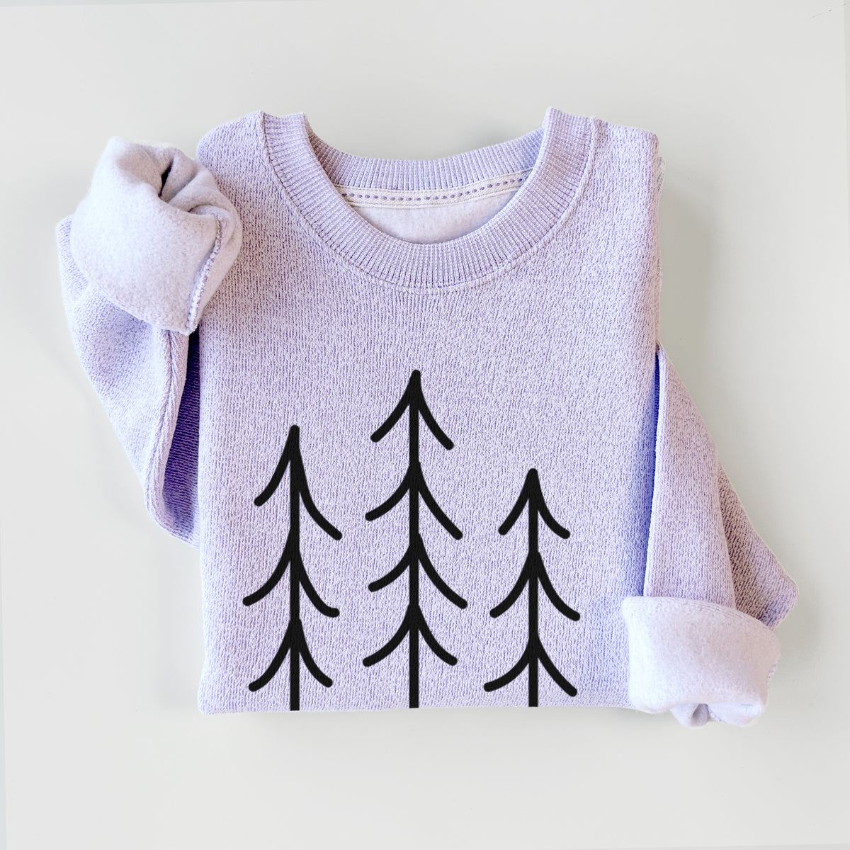 Ice purple knit sweatshirt printed with black line art of three simple pine trees above horizontal lines, styled flat.