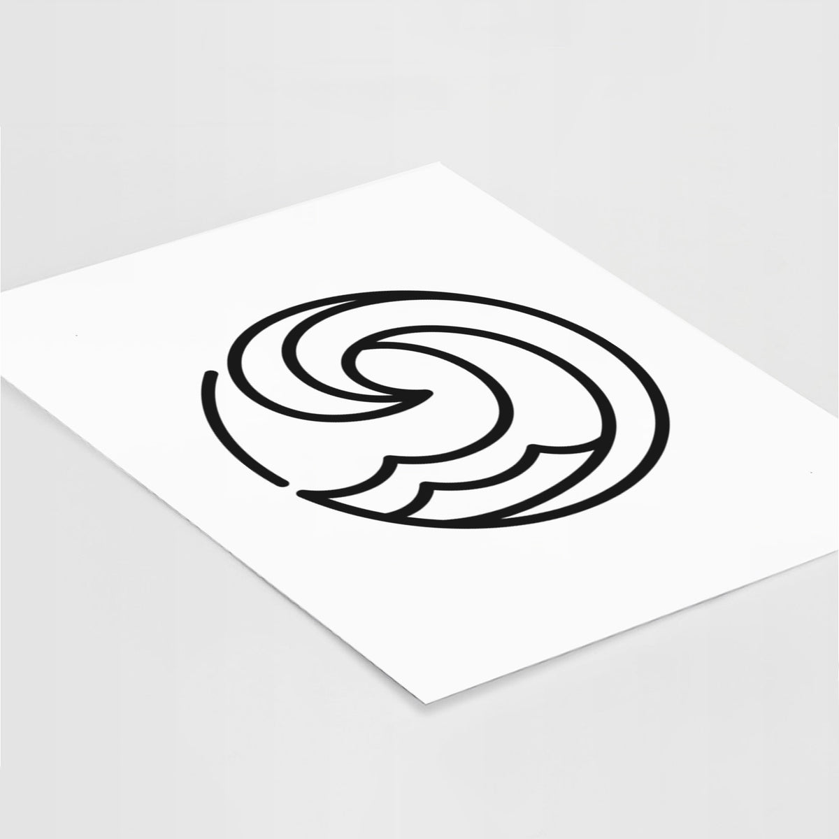 Art print of a bold black line art circle of a curling ocean wave, lying at an angle on a white surface.