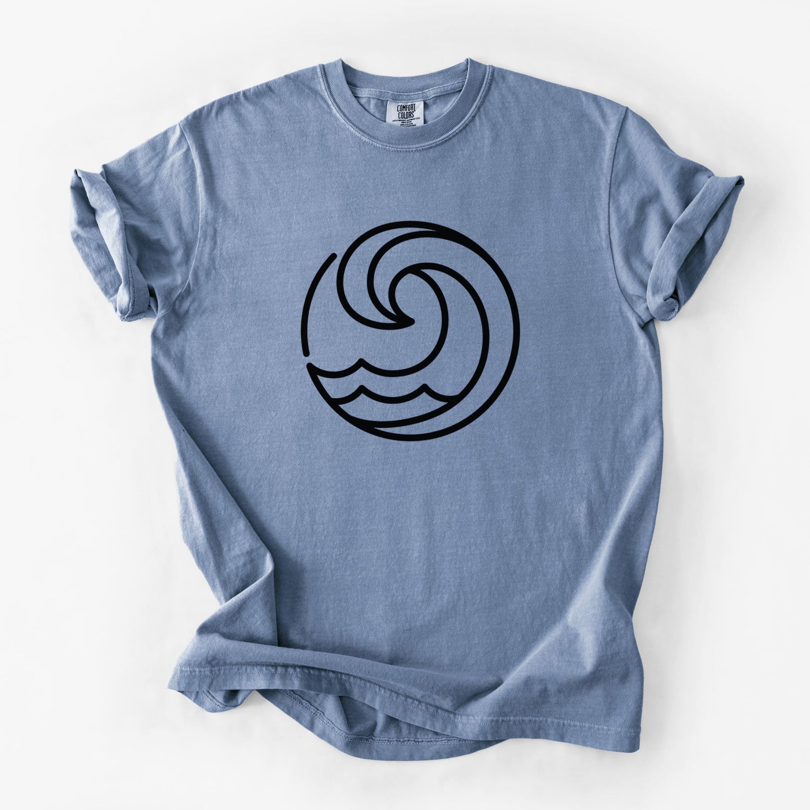 Blue jean Comfort Colors t-shirt laid flat, printed with a bold black line art circle of a curling ocean wave.