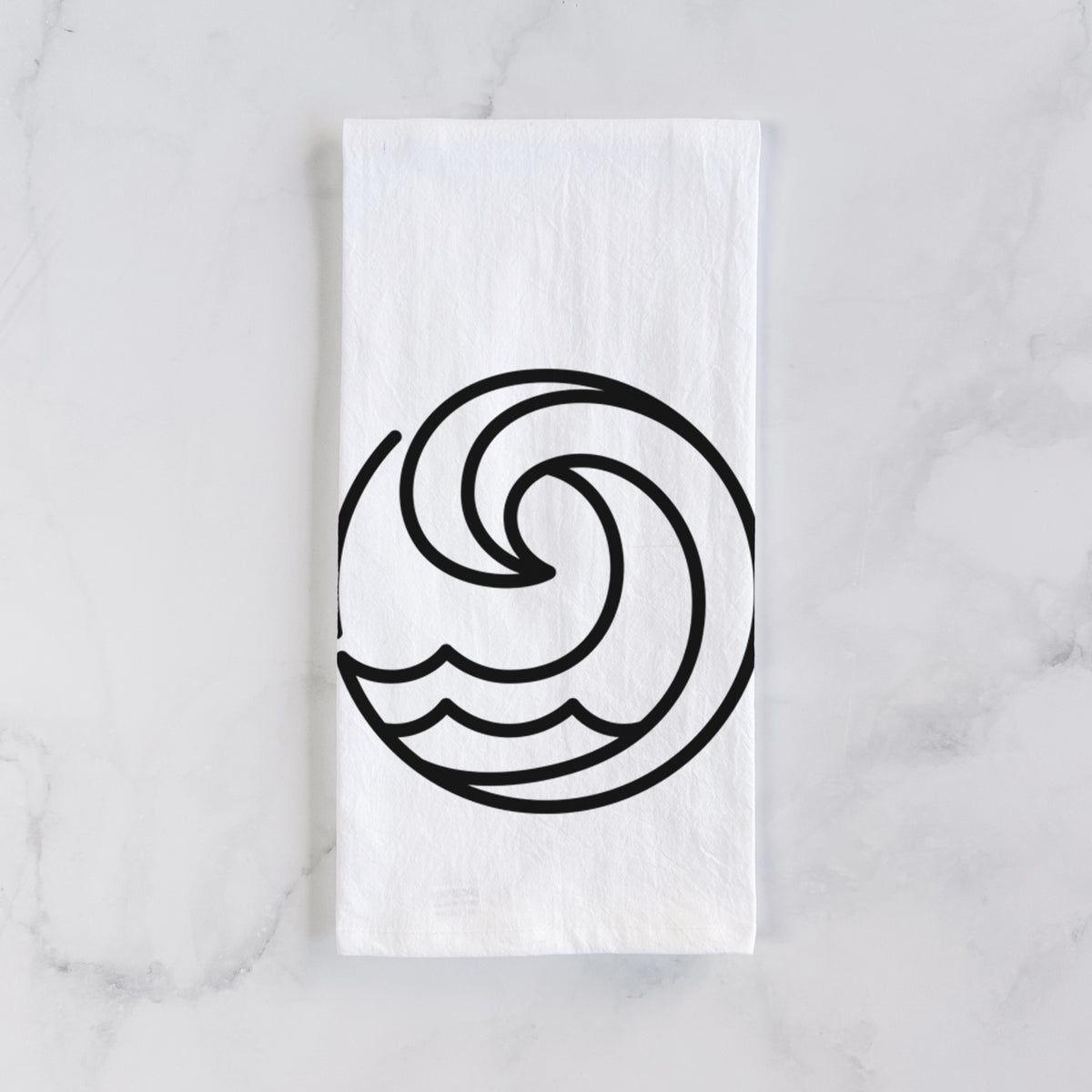 White cotton tea towel laid flat on marble, printed with a bold black line art circle of a curling ocean wave.