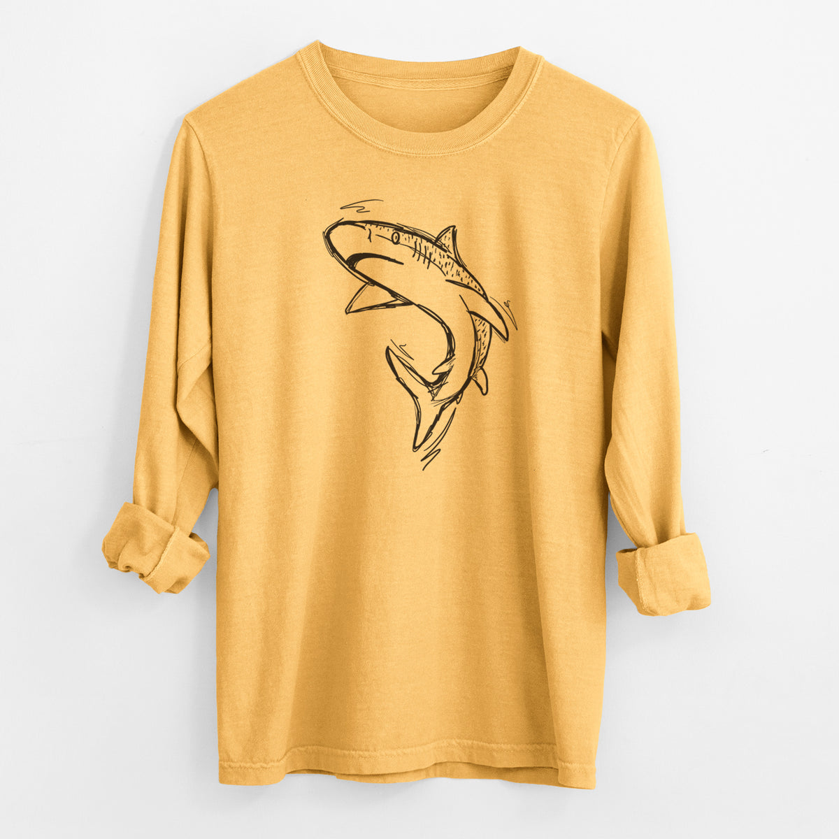 Golden wheat yellow Comfort Colors long sleeve shirt laid flat with the cuffs rolled, printed with a black ink illustration of a tiger shark swimming in a curve.