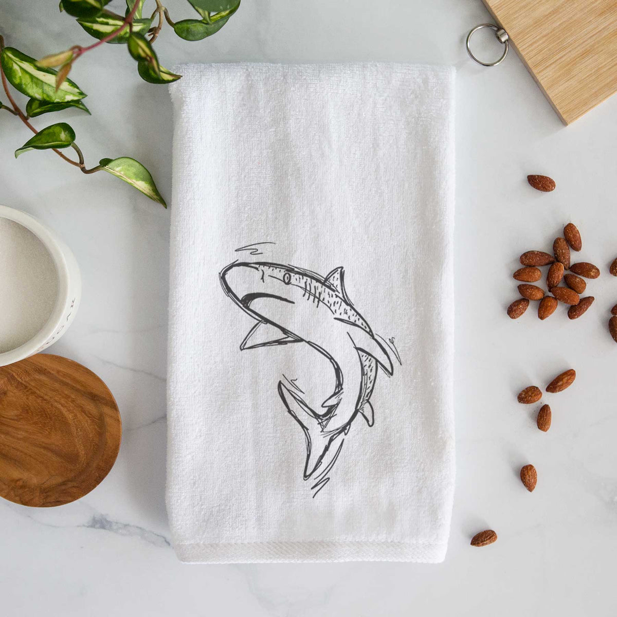 White hand towel printed with a black ink illustration of a tiger shark swimming in a curve.