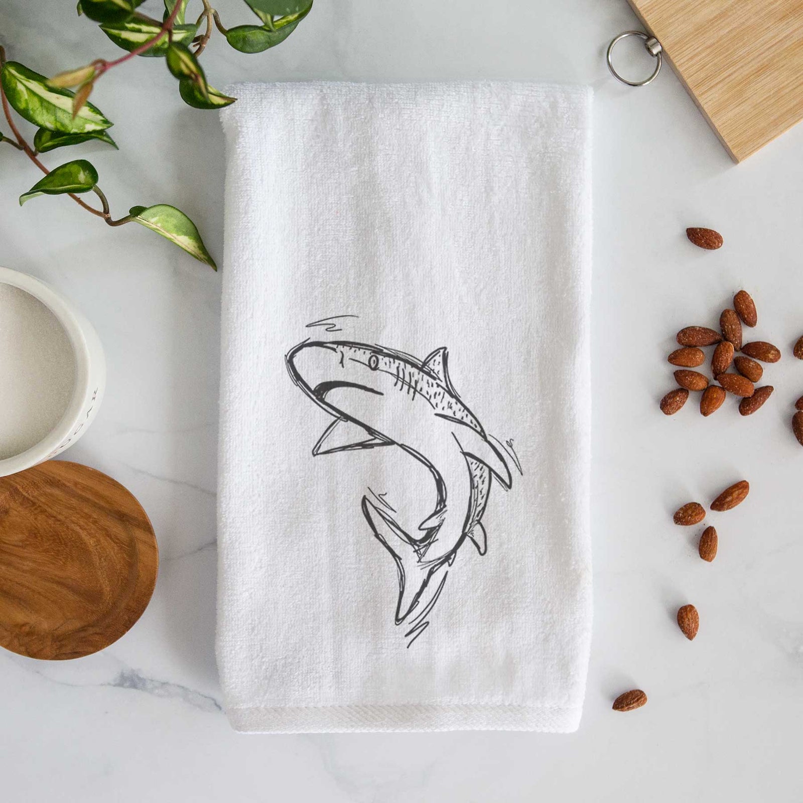White hand towel printed with a black ink illustration of a tiger shark swimming in a curve.