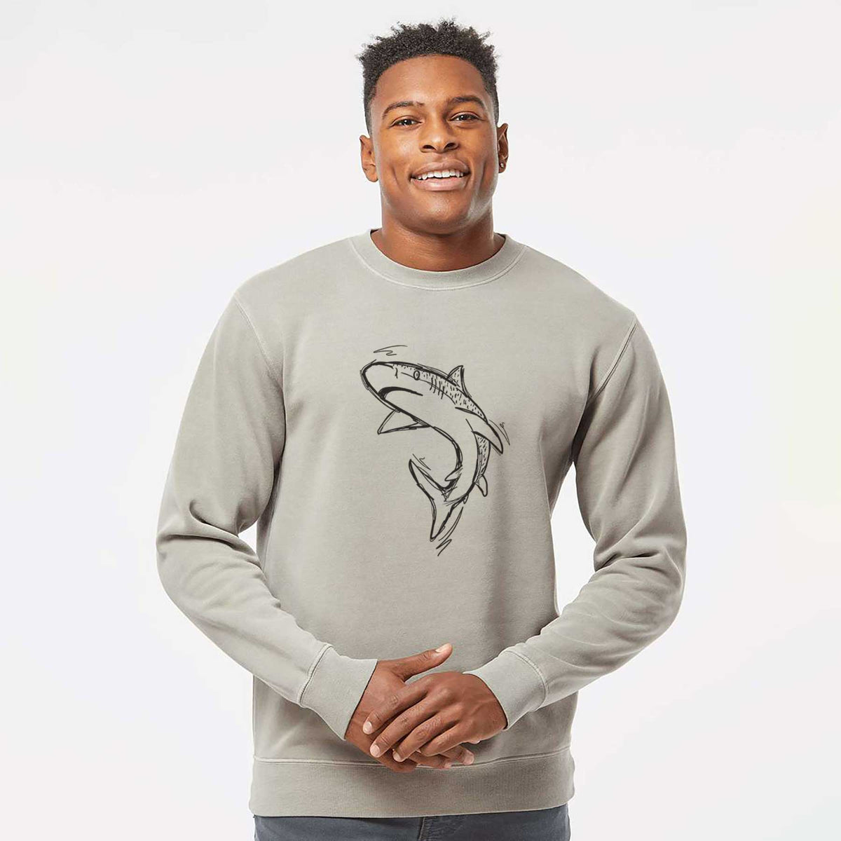 Model wearing a cement grey pigment dyed crewneck sweatshirt printed with a black ink illustration of a tiger shark swimming in a curve.