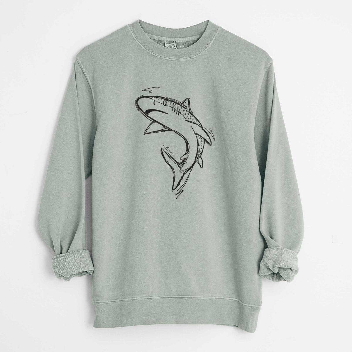 Sage green pigment dyed crewneck sweatshirt laid flat with the sleeves rolled, printed with a black ink illustration of a tiger shark swimming in a curve.