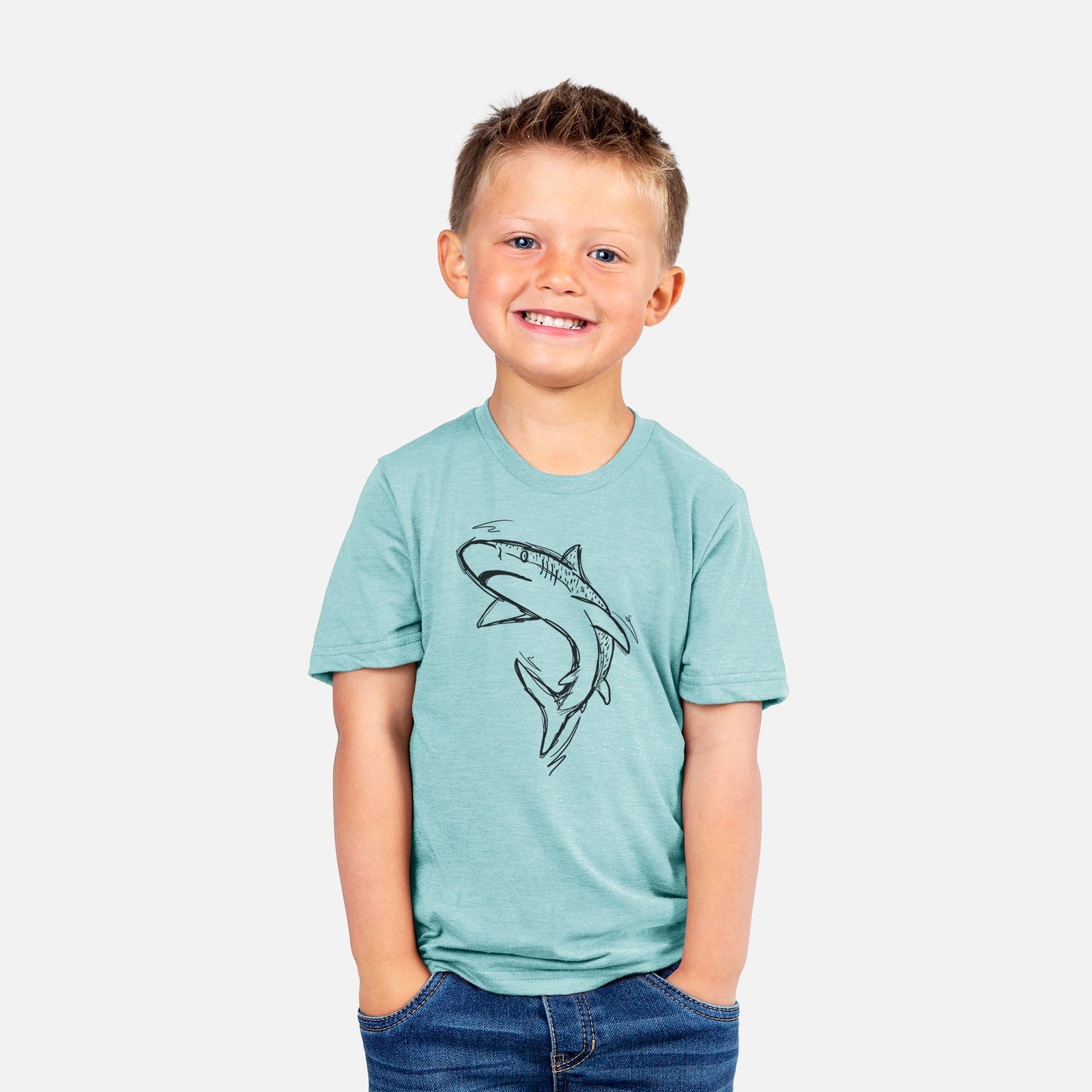 Two youth t-shirts in different colors on hangers, printed with a black ink illustration of a tiger shark swimming in a curve.