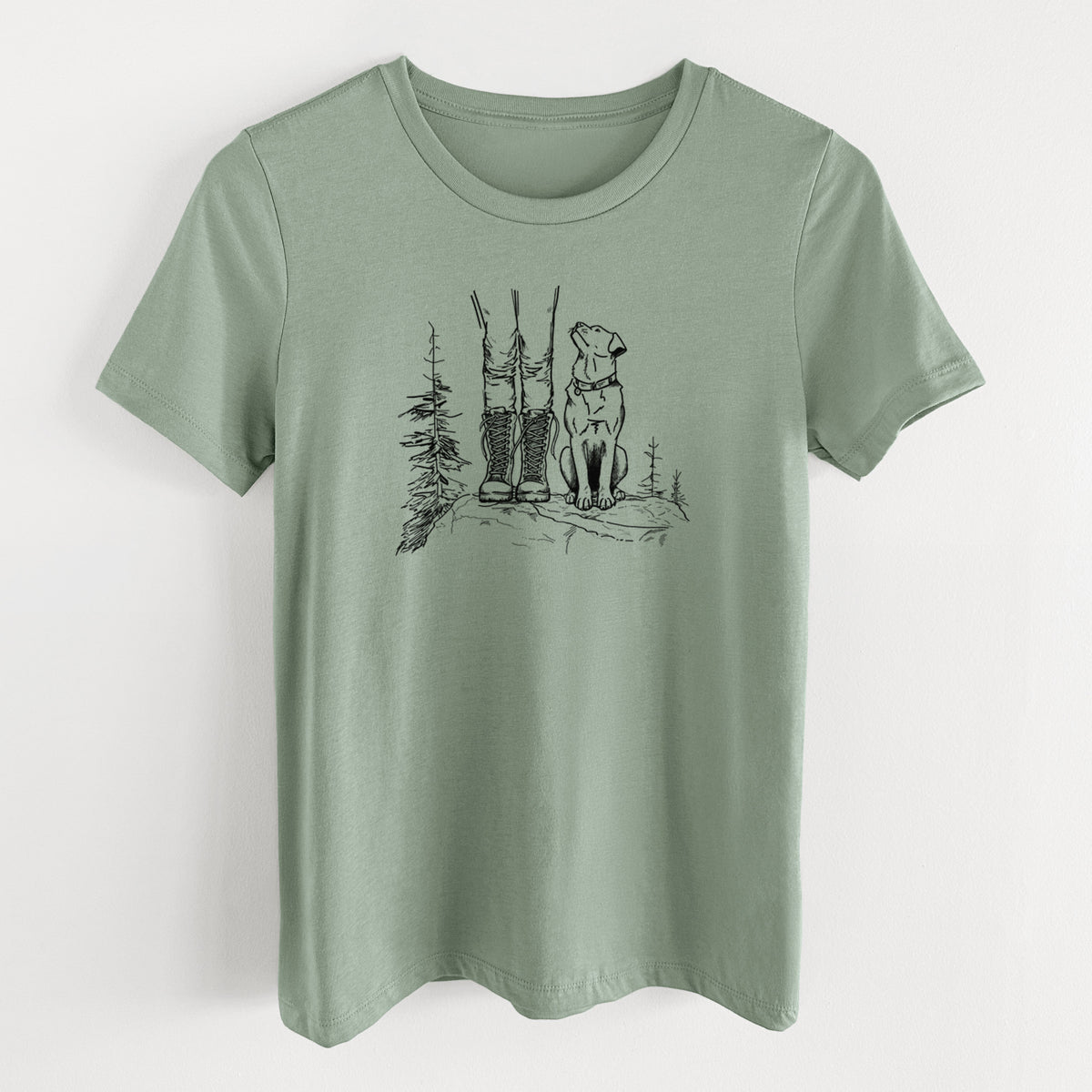 Sage green women's relaxed fit cotton t-shirt laid flat, printed with a black ink illustration of a hiker in boots and a dog sitting side by side on a forest trail, seen from behind.