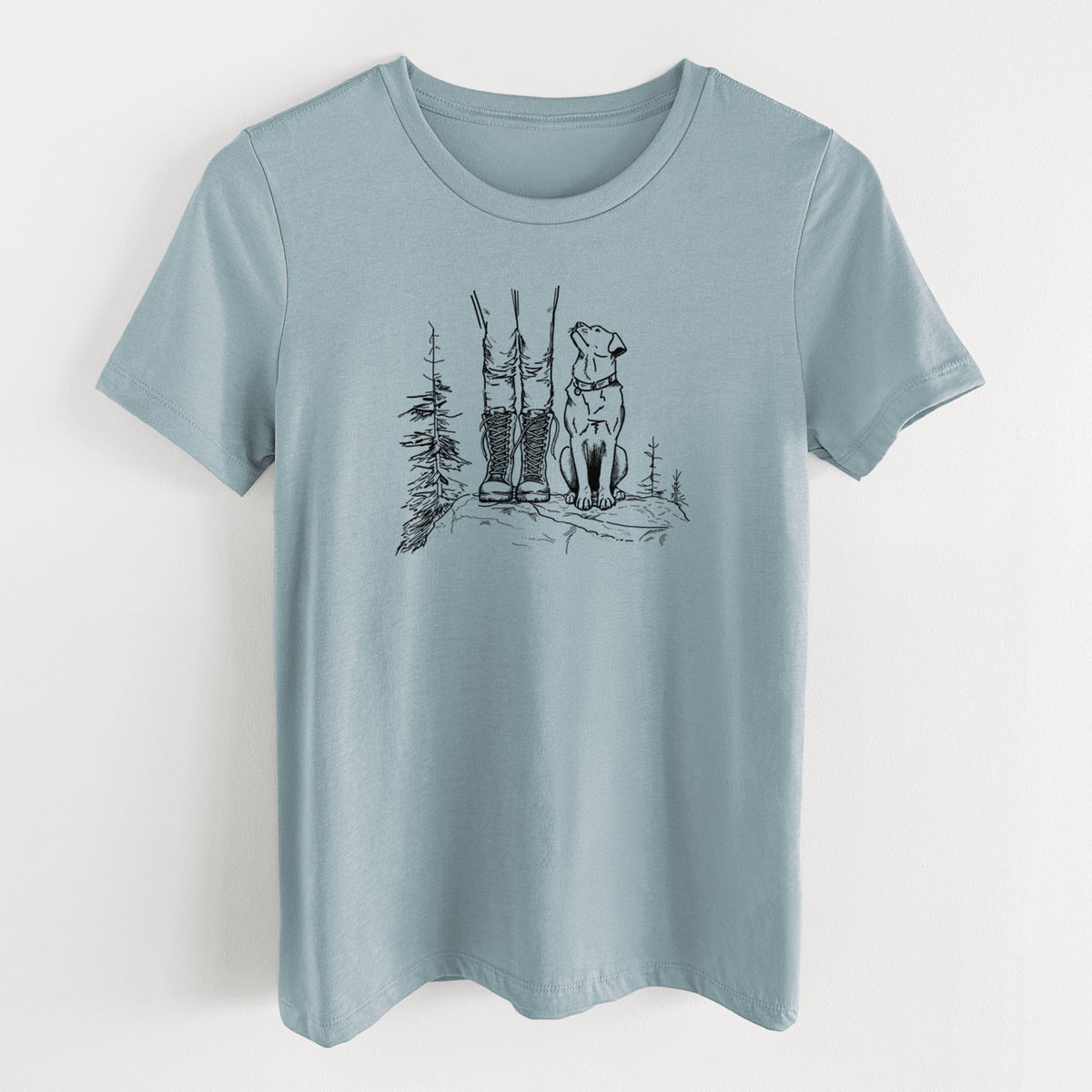 Vintage denim women's relaxed fit cotton t-shirt laid flat, printed with a black ink illustration of a hiker in boots and a dog sitting side by side on a forest trail, seen from behind.