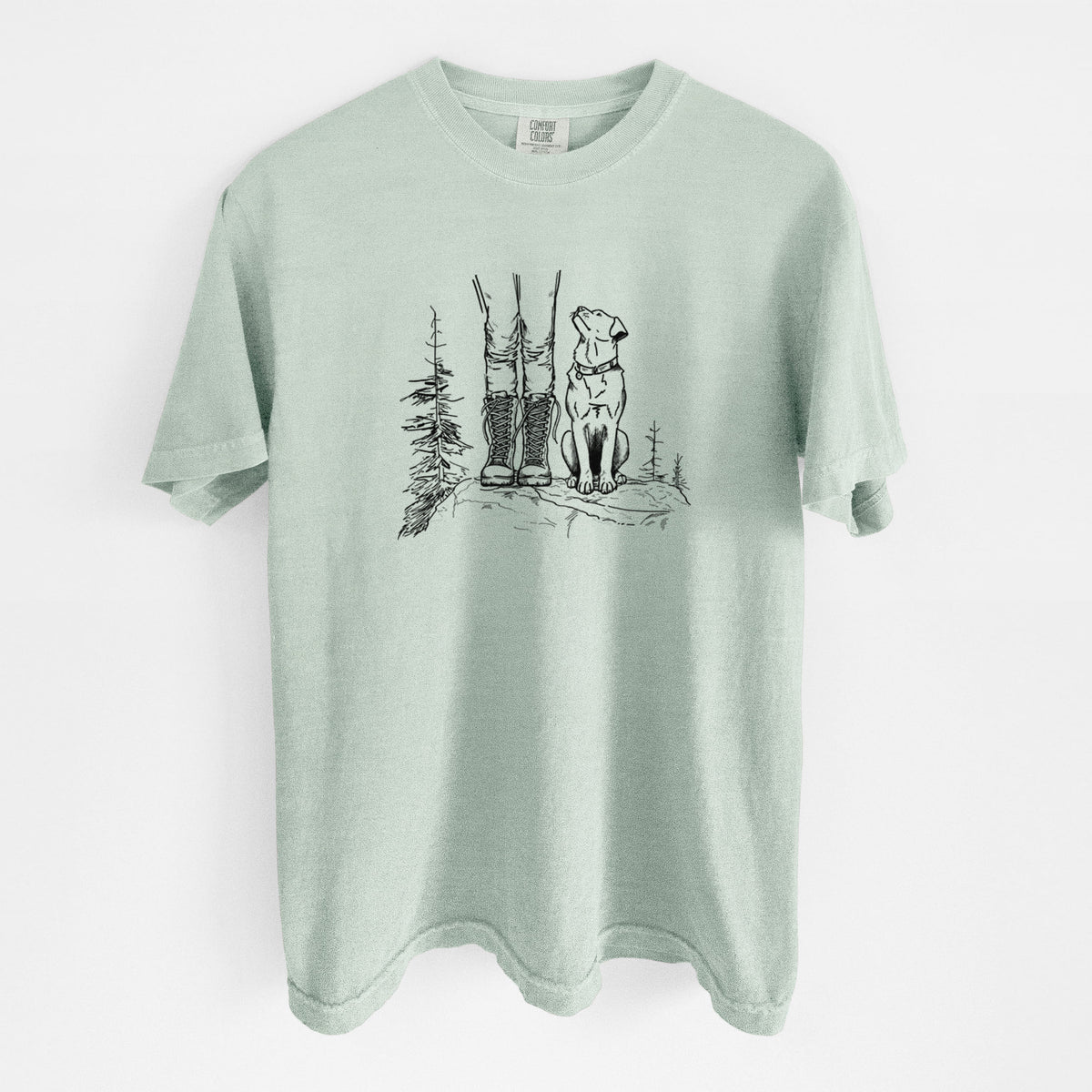 Bay green Comfort Colors t-shirt laid flat, printed with a black ink illustration of a hiker in boots and a dog sitting side by side on a forest trail, seen from behind.