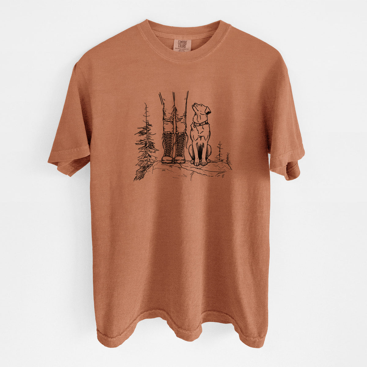 Yam burnt orange Comfort Colors t-shirt laid flat, printed with a black ink illustration of a hiker in boots and a dog sitting side by side on a forest trail, seen from behind.
