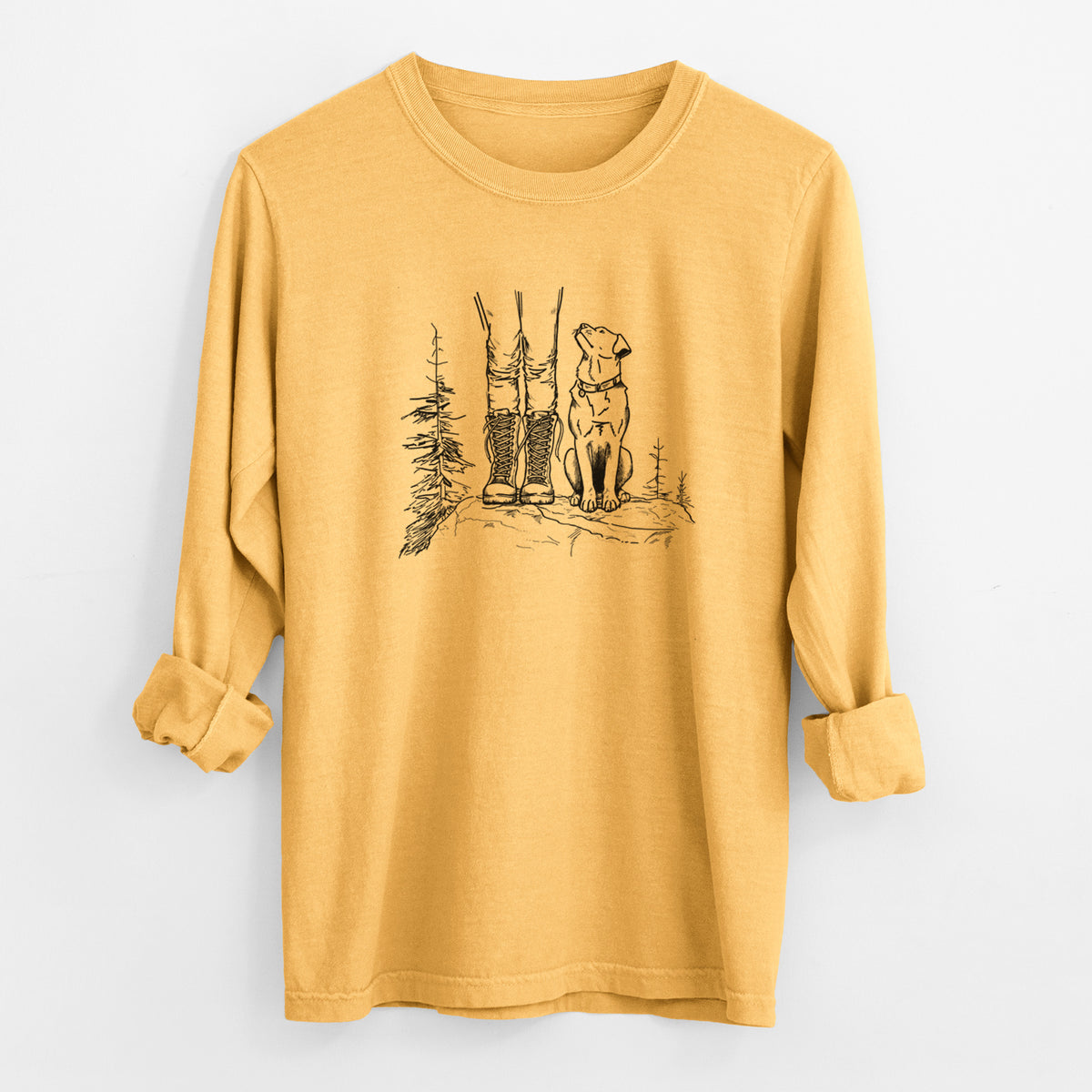 Golden wheat yellow Comfort Colors long sleeve shirt laid flat with the cuffs rolled, printed with a black ink illustration of a hiker in boots and a dog sitting side by side on a forest trail, seen from behind.