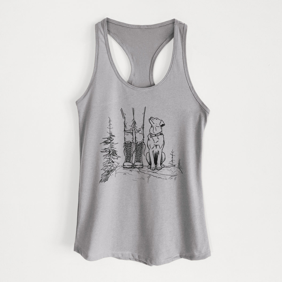 Heather grey women's racerback tank top laid flat, printed with a black ink illustration of a hiker in boots and a dog sitting side by side on a forest trail, seen from behind.