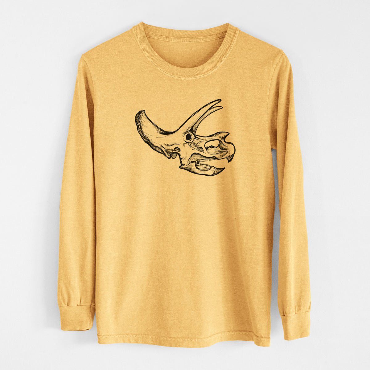 Golden wheat yellow Comfort Colors long sleeve shirt laid flat, printed with a detailed black ink illustration of a Triceratops skull with its horns and frill.