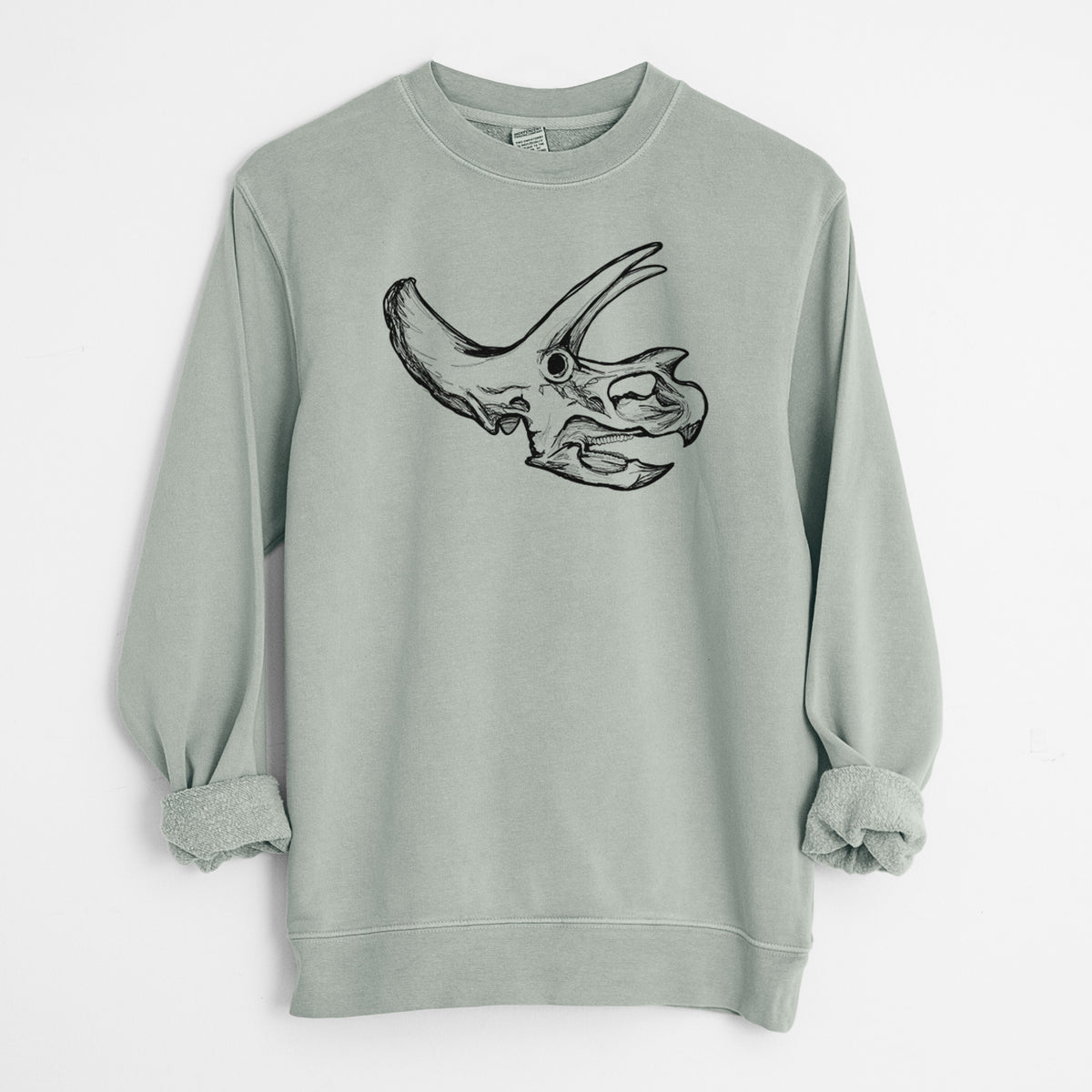 Sage green pigment dyed crewneck sweatshirt laid flat with the sleeves rolled, printed with a detailed black ink illustration of a Triceratops skull with its horns and frill.